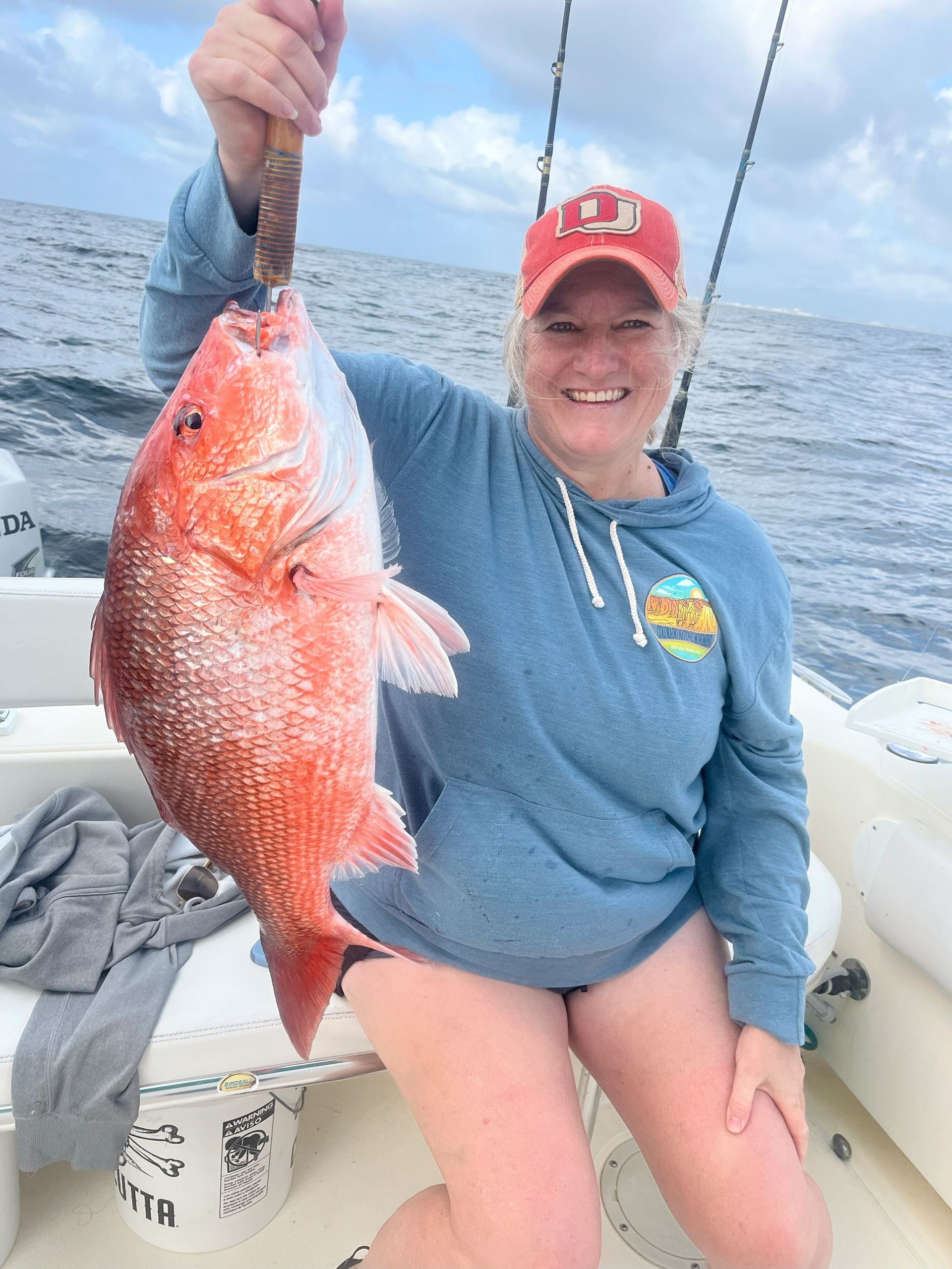 Guest holding a red snapper caught on a Destin charter.